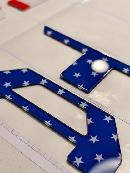 Two blue license plate frames with white star patterns 